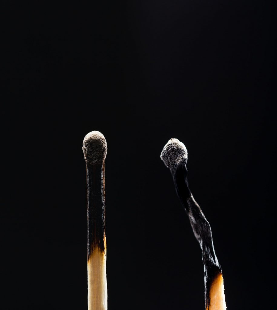 Two burned out wooden matches on black